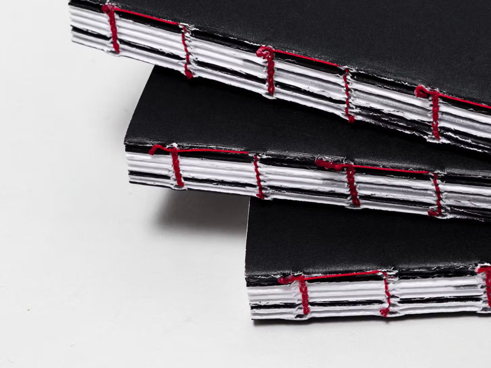 Hand-bound notebooks stacked on a desk