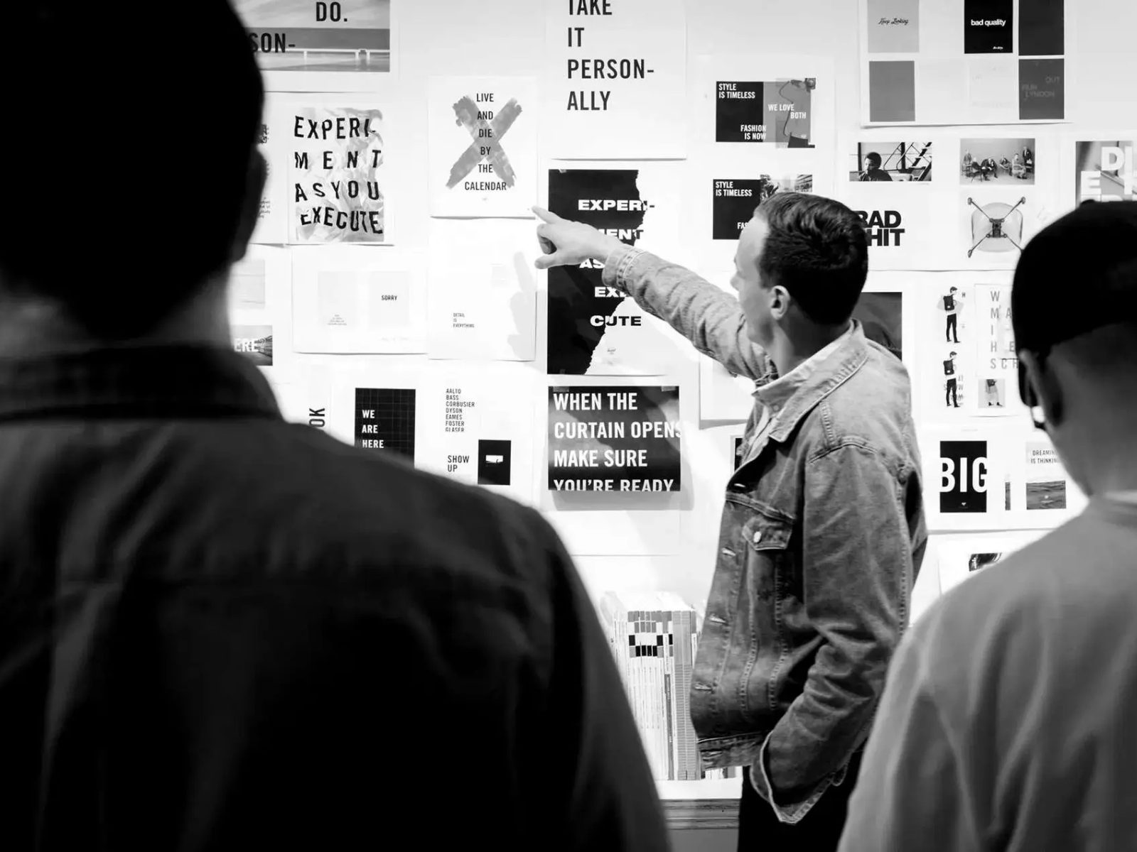 The team talking through work pinned to the studio wall