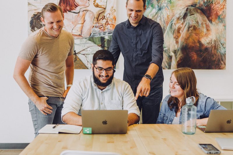 A team working together around a laptop